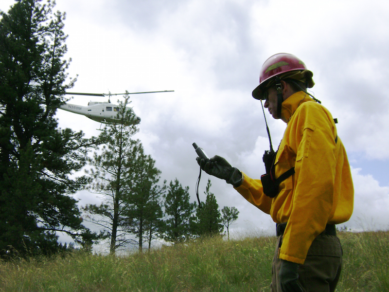 man looking at device, helicopter flying overhead