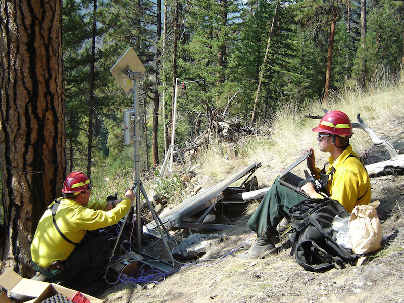 fire monitors setting up a wireless network in the forest for monitoring