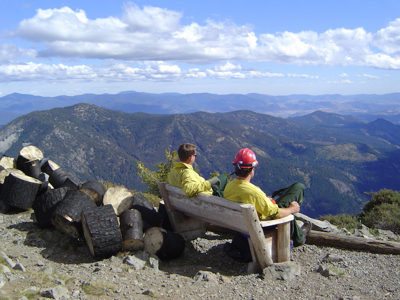 fire monitors sitting on bench overlooking mountain tops