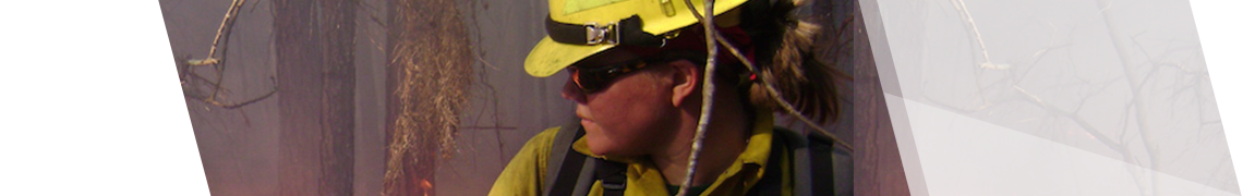 Female firefighter looking back at wildfire